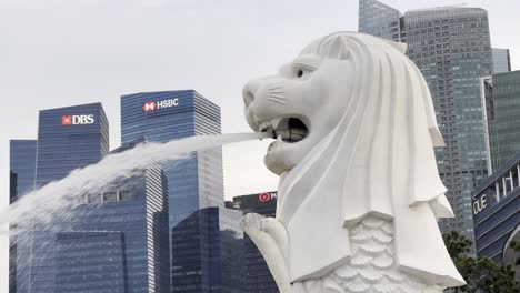 Close-up-of-iconic-Singapore-mascot,-mythical-creature-merlion-at-downtown-metropolitan-area-with-business-and-financial-buildings-in-the-background
