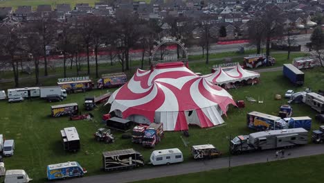 Planet-circus-daredevil-entertainment-colourful-swirl-tent-and-caravan-trailer-ring-aerial-view-slow-push-in-tilt-down