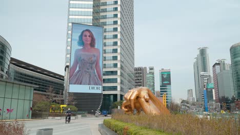 Statue-Einer-Skulptur-Im-Gangnam-Stil-Und-Elektronische-Anzeige-Des-Coex-Media-Tower-In-Gangnam-Gu,-Seoul,-Südkorea