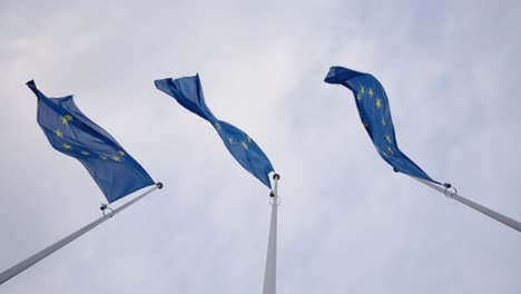 Pov-Blickt-Tagsüber-Im-Wind-Auf-Die-Flaggen-Der-Europäischen-Union---Zeitlupe