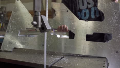 Worker-Cutting-Aluminum-Plate-On-A-Industrial-Bandsaw-In-A-Workshop