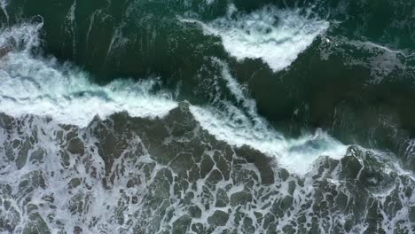 Top-down-drone-shot-of-West-Coast-waves-crashing-on-a-rocky-shore