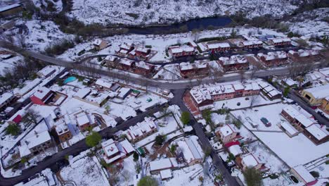 High-angle-birdseye-view-over-the-homes-and-buildings-of-Pradera-de-Navalhorno-on-a-chilly-snow-covered-winter's-day