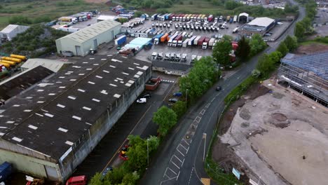 Truck-shipping-cargo-through-industrial-warehouse-depot-storage-facility-UK-business-retail-park-aerial-view
