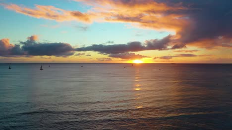 Tropical-Hawaiian-Sunrise-Over-Boats-Sailing-Across-Colorful-Sea-Near-Waikiki-Beach-In-Honolulu,-Hawaii