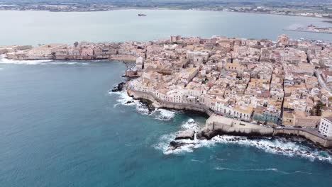 drone-view-over-the-whole-ortigia-of-siracusa-in-sicily-in-italy,-wavy-sea