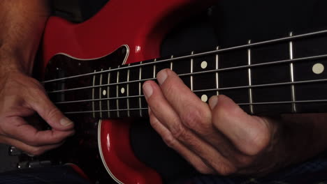 Medium-close-up-shot-of-electric-bass-playing-using-right-thumb-hand