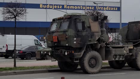 Tanker-Hemtt-Der-US-Armee-Mit-Einem-Humvee,-Der-Entlang-Der-Straße-Im-Hintergrund-In-Polen-Geparkt-Ist