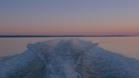 Wasserspray-Aus-Dem-Kielwasser-Eines-Kleinen-Motorbootes-Bei-Sonnenuntergang