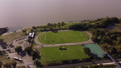People-training-at-waterfront-soccer-field-in-front-of-Rio-De-La-Plata-river-in-Buenos-Aires,-Argentina