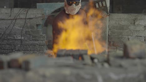 A-Ironworker-Fuelling-A-Fire-In-A-Iron-Forging-Workshop