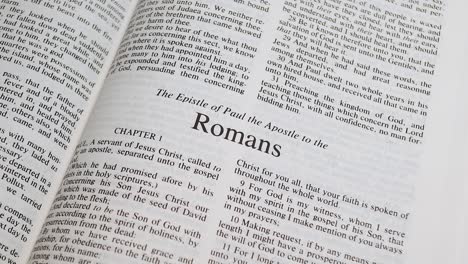 Close-Up-Shot-of-Bible-Page-Turning-to-the-book-of-Romans