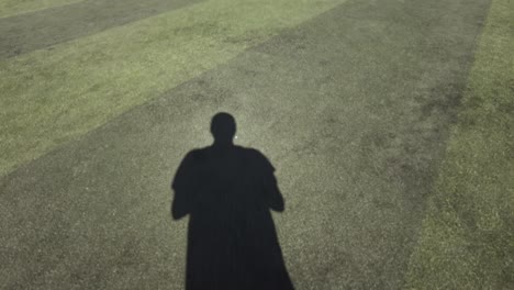 POV-Of-Male-Following-Shadow-On-Football-Pitch-On-Sunny-Day