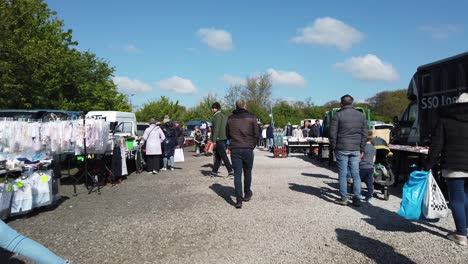 Flea-market-people-browsing-busy-British-weekend-car-boot-sale-for-unwanted-goods