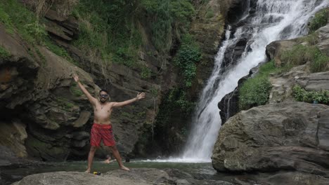 Statische-Aufnahme-Eines-Asiatischen-Mannes,-Der-Die-Kühle-Brise-Der-Ravana-Wasserfälle-Genießt,-Ella,-Sri-Lanka