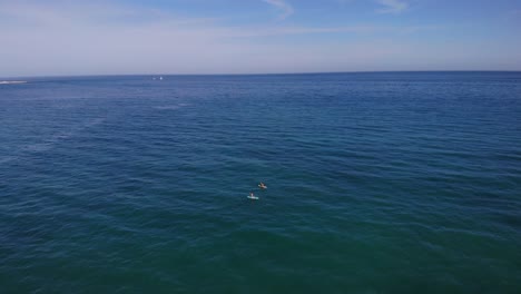 Aerial-View-Of-Two-People-Kayaking-In-The-Blue-Ocean-Near-Estepona-In-Costa-del-Sol,-Spain