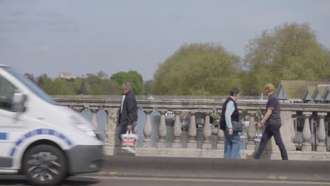 Cars-driving-and-people-walking-over-bridge-in-London,-static-view