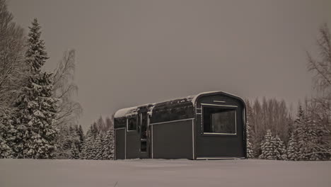 Timelapse-shot-of-scenic-winter-landscape-with-wooden-cabin-covered-with-snow