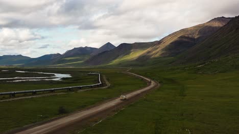Van-driving-on-Portage-Glacier-road-throw-the-Portage-valley-along-Trans-Alaska-crude-oil-Pipeline-by-the-mountains---Aerial-wide-following-shot