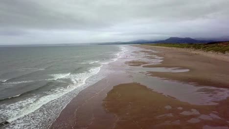 Ariel-view-of-Harlech-beach-Wales-with-vast-sands-crashing-waves-and-a-stormy-sky
