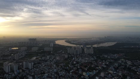 Aerial-view-overlooking-the-Binh-Khanh-and-the-Saigon-river,-foggy,-sunset-in-Ho-chi-minh,-Vietnam---tracking,-drone-shot