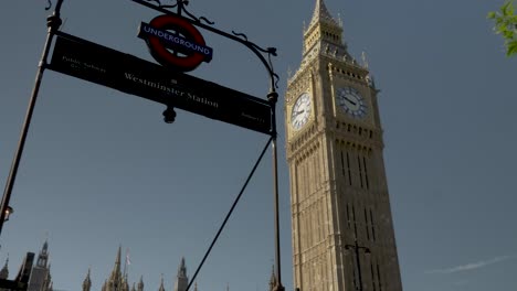 Una-Toma-En-ángulo-Bajo-De-La-Famosa-E-Icónica-Torre-Del-Reloj-Big-Ben-Desde-El-Letrero-Subterráneo-De-La-Estación-De-Westminster,-Londres,-Inglaterra