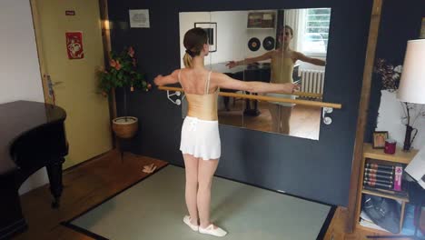 Ballerina-beginner-practices-basic-steps,-corrects-herself-in-mirror
