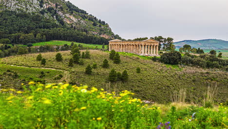 Static-view-to-the-Doric-temple-of-Segesta,-Province-of-Trapani,-Sicily,-Italy-at-daytime-in-timelapse-in-rural-countryside-over-hilly-terrain