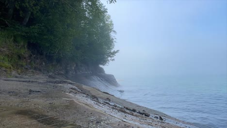 Zeitraffer-Felsige-Küste-Mit-Ruhigen-Wellen-An-Einem-Nebligen-Tag,-Abgebildete-Felsen-Des-Lake-Superior-Mit-Bäumen-Am-Nationalen-Seeufer