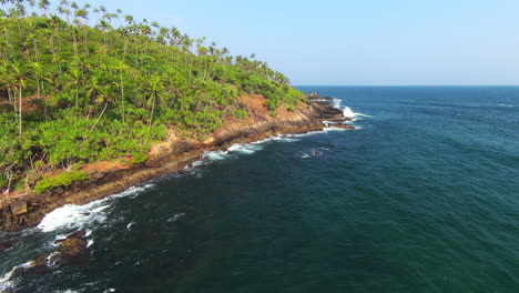 FPV-Rising-Up-From-Sea-Over-High-Green-Hill-Full-Of-Palm-Trees,-Sri-Lanka