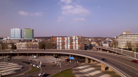 Aerial-ascend-and-pan-revealing-transit-roundabout-intersection-in-the-middle-of-Dutch-city-Arnhem-with-graphic-asphalt-floor