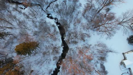 Top-view,-Winter-landscape-of-the-river-with-a-forest-among-snow-in-countryside