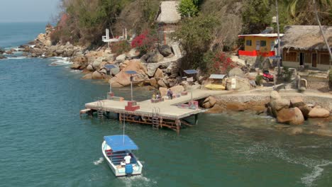 Drone-Following-Water-Taxi-Arriving-At-The-Pier-In-Yelapa,-Jalisco,-Mexico-In-Summer