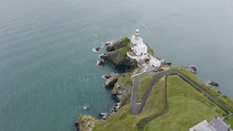 Aerial-view-of-the-beautiful-Baily-Lighthouse-on-a-cliff-in-Howth,-Ireland