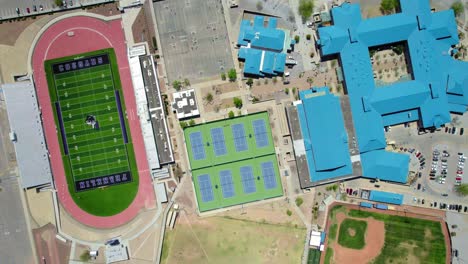 Aerial-Drone-Flying-Over-Large-Colorful-High-School-Campus-Buildings,-Football-Field,-and-Baseball-Field-in-West-El-Paso,-Texas