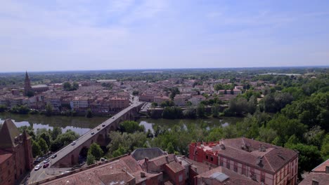 Saint-James-cathedral,-Old-Bridge-and-Ingres-Museum-approaching-in-Montauban-France,-Aerial-flyover-shot