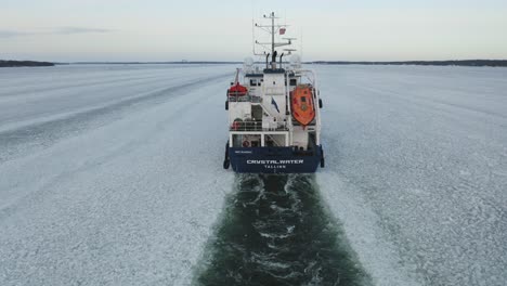 Aerial-following-tracking-view-of-oil-and-chemical-tanker-CRYSTALWATER-call-sign-ESLI-moving-ahead-in-ice-covered-Finnish-archipelago