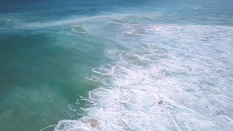 Top-down-aerial-view-of-the-powerful-deep-blue-ocean-waves-in-winter