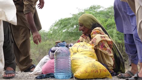 Pair-Of-Sandals-Given-To-Elderly-Pakistani-Woman-Sat-By-Roadside-During-Flood-Relief-In-Balochistan