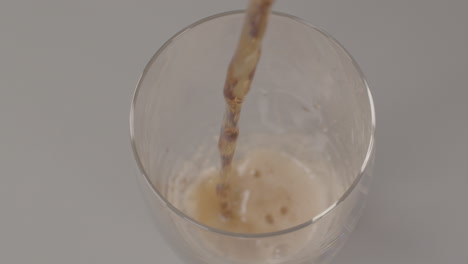 High-angle-view-of-glass-being-filled-with-cola-in-slow-motion