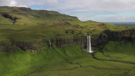 Seljalandsfoss-waterfalls-in-Iceland-with-drone-video-moving-out-wide-shot