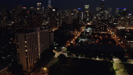Die-Skyline-Von-Chicago-Wird-Nachts-Sichtbar,-Wenn-Eine-Drohne-Zwischen-Wolkenkratzern-Fliegt