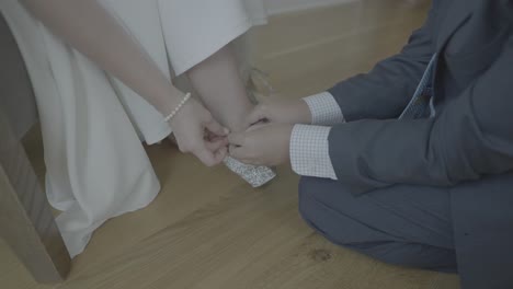 Groom-tying-shoes-for-his-bride.-Medium-Shot