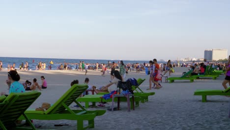 The-video-shows-one-of-the-world's-most-picturesque-beaches-in-DA-NANG,-Vietnam,-with-a-large-number-of-tourists-strolling-down-the-shore,-sitting-on-the-beach-chair-and-having-fun-in-the-water