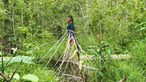 Mujer-Joven-En-El-Bosque-Está-Caminando-Detrás-De-Ramas-De-Plantas-Secas