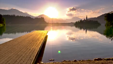 Wunderschöner,-Wunderschöner-Sonnenaufgang-Im-Zeitraffer-In-Bled-Mit-Einer-Winzigen-Insel,-Die-Sich-Im-Teich-Spiegelt,-Während-Sich-Wolken-Im-Hintergrund-Bewegen,-Bled,-Slowenien,-2019
