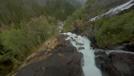 Aerial-drone-flight-downhill-Låtefoss-Waterfall-into-valley-in-Norway