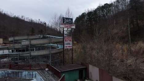 Drone-Footage-Rising-in-Front-of-the-Fugates-Entertainment-Center-Sign-in-Eastern-Kentucky-with-the-Abandoned-Waterslides-Sitting-in-the-Background