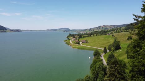 Aerial-shot-moving-through-trees-to-reveal-lake-Sihlsee-in-Switzerland