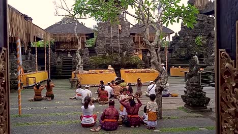 Balineses-Rezando-Templo-Hindú-Ubud-Sacerdote-Bendiciendo-A-Una-Familia-Vestida-Tradicional-Ofreciendo-Rituales-Para-Los-Dioses